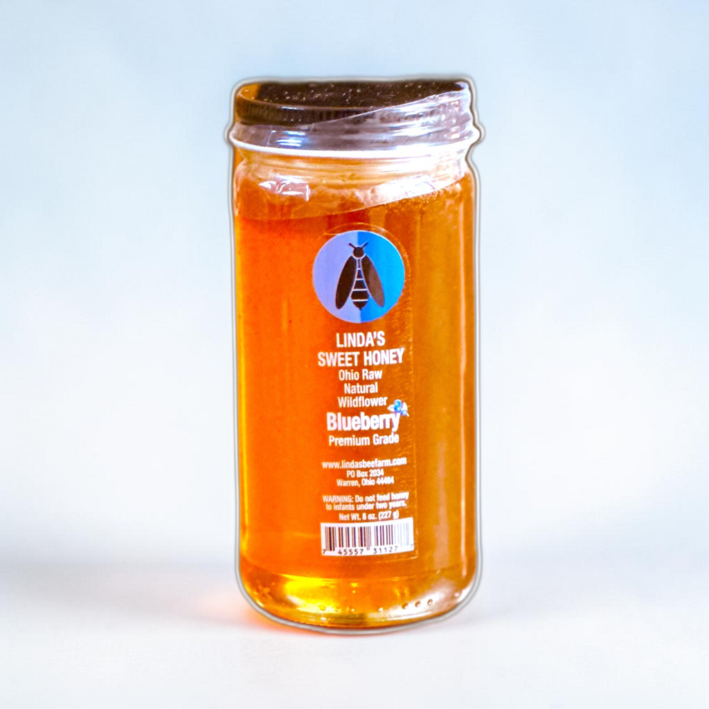 Jar of Linda's Blueberry Fusion honey on a light blue background