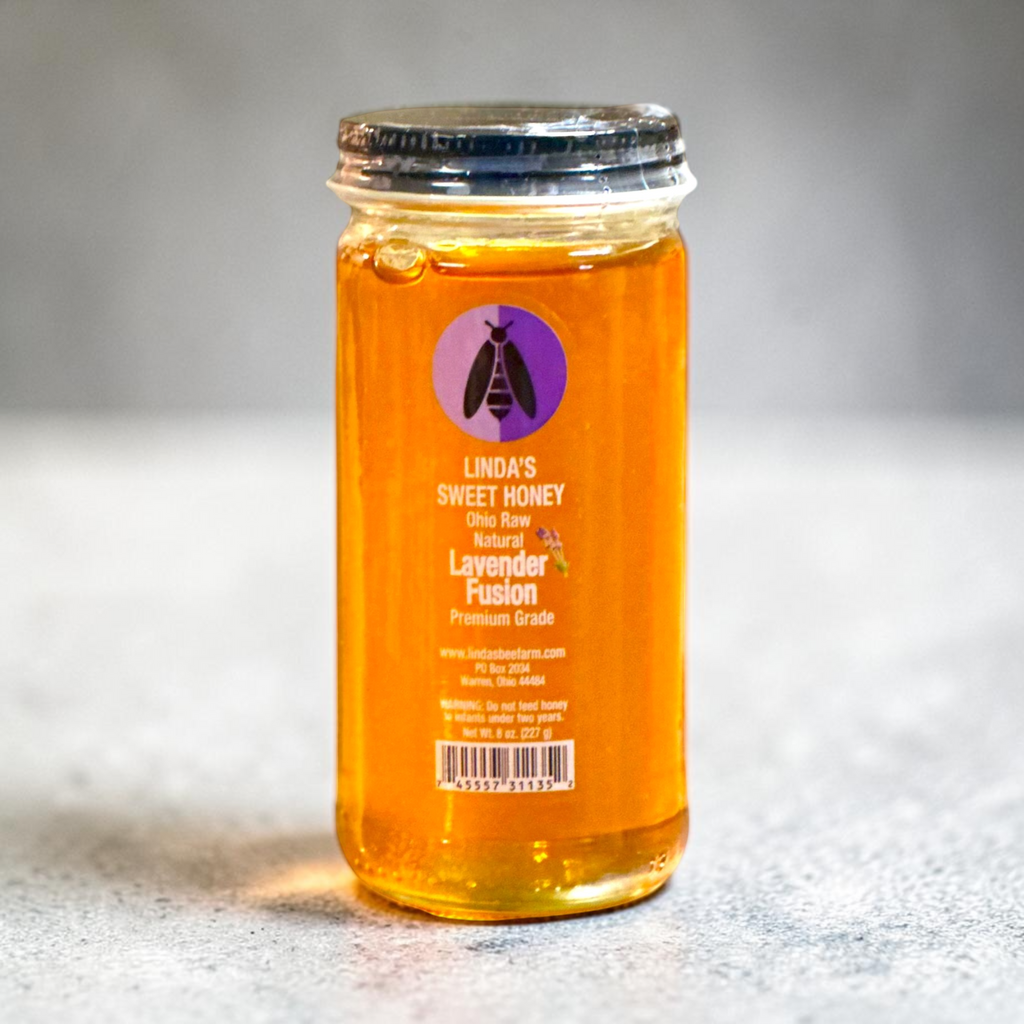 Jar of Linda's Lavender Fusion honey on a gray stone surface