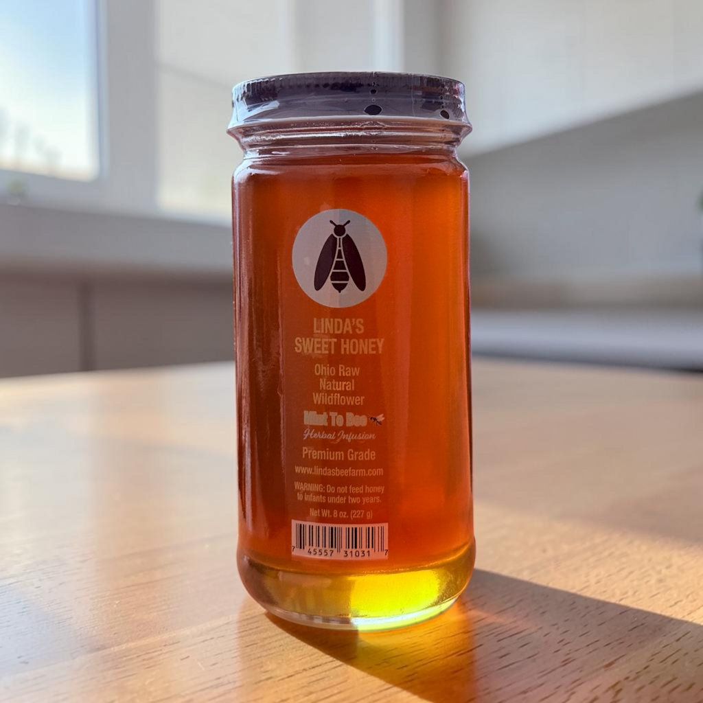Jar of Linda's Mint Fusion wildflower honey on a wooden table in natural sunlight